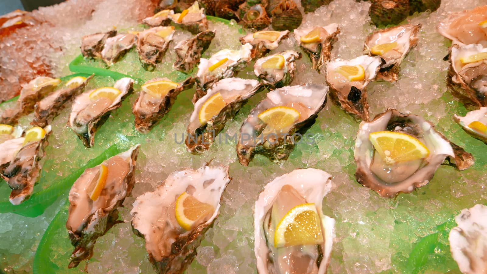 Some oysters are on the ice tray with lemon