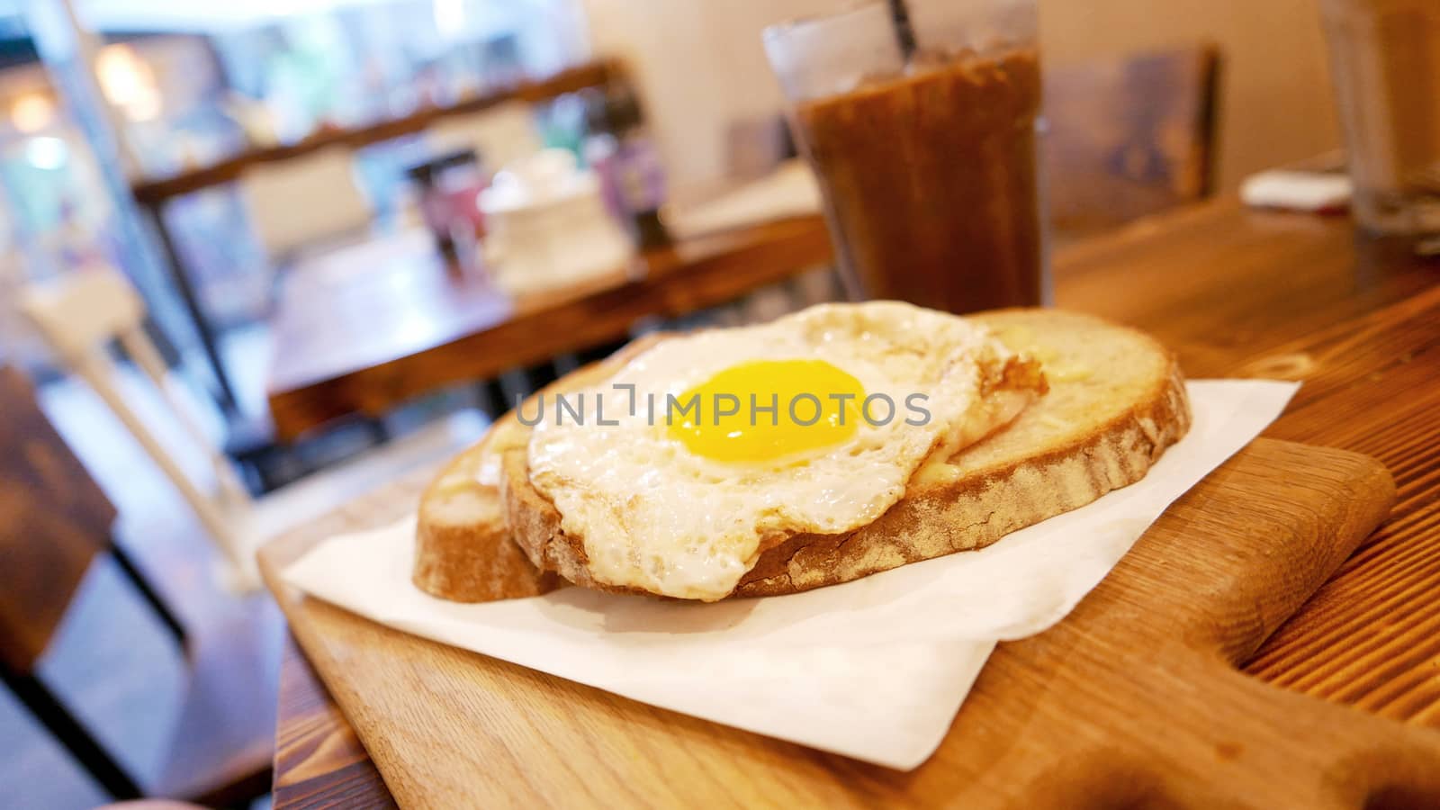 Breakfast sun egg bread with cold drink on the wooden table by cougarsan