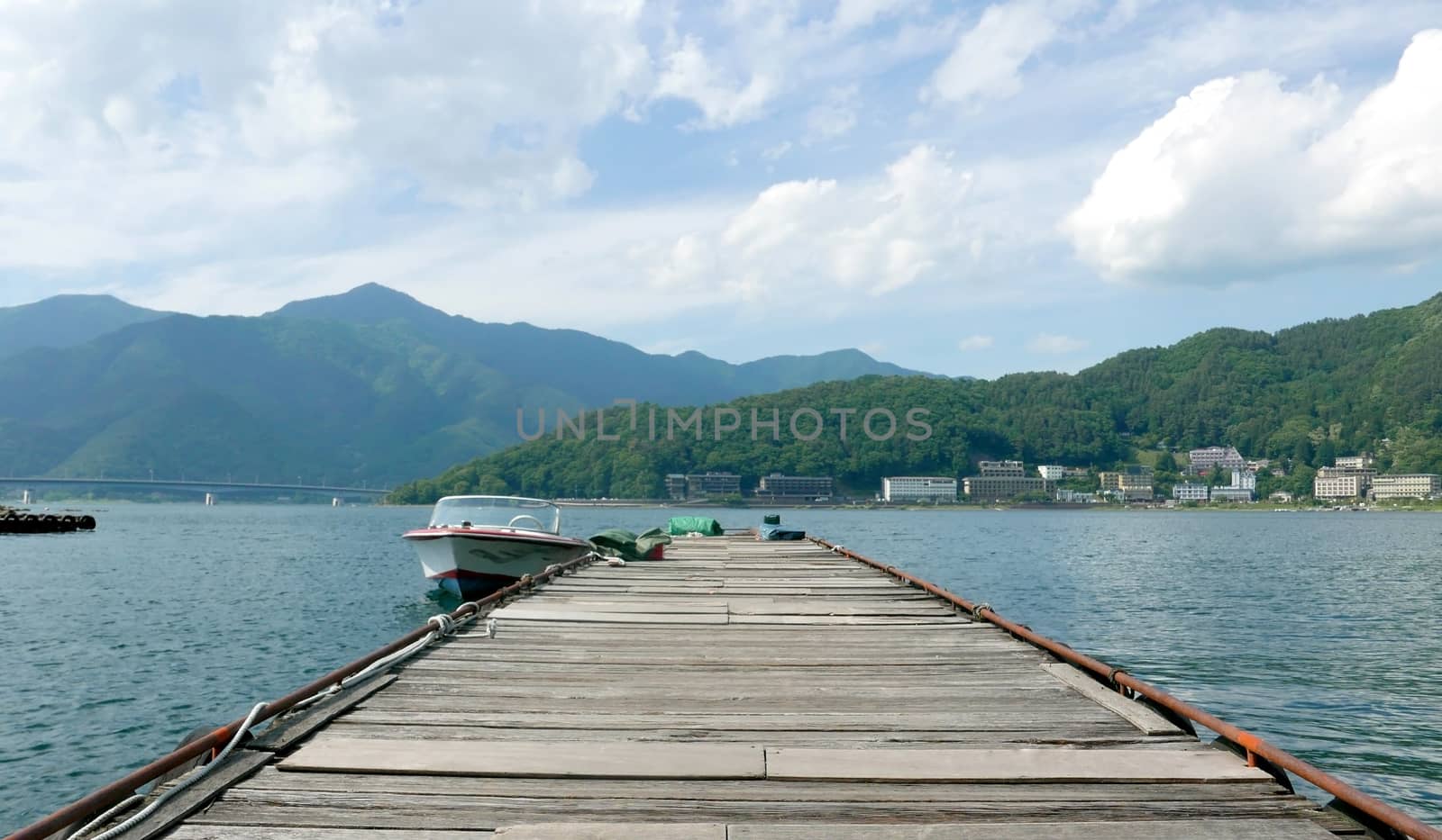 The mountain, recreational wooden boats, clouds, lake, blue sky and sun in Hong Kong