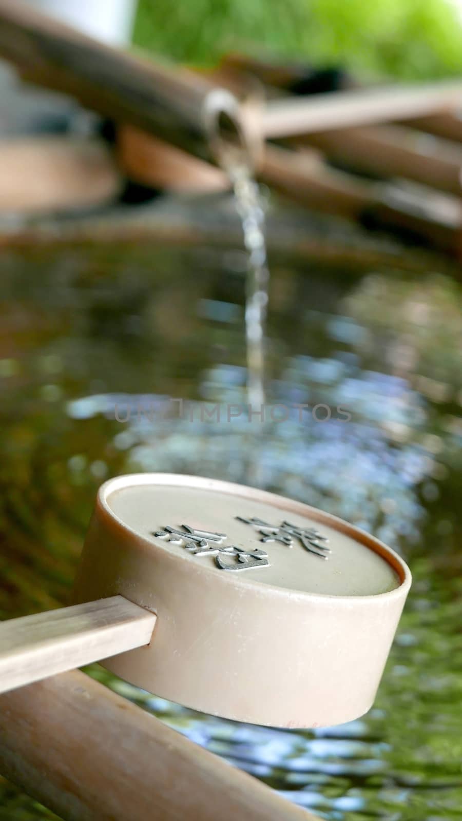 Water flowing from bamboo and spoon in zen garden by cougarsan