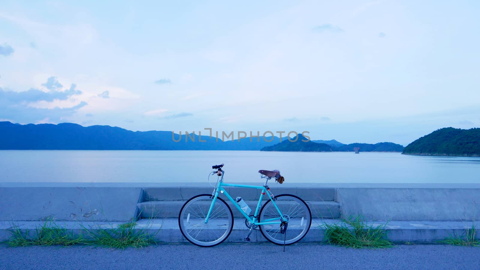 Bicycle retro style with leather seat and bagBicycle, road, cloud and lake in the early evening by cougarsan