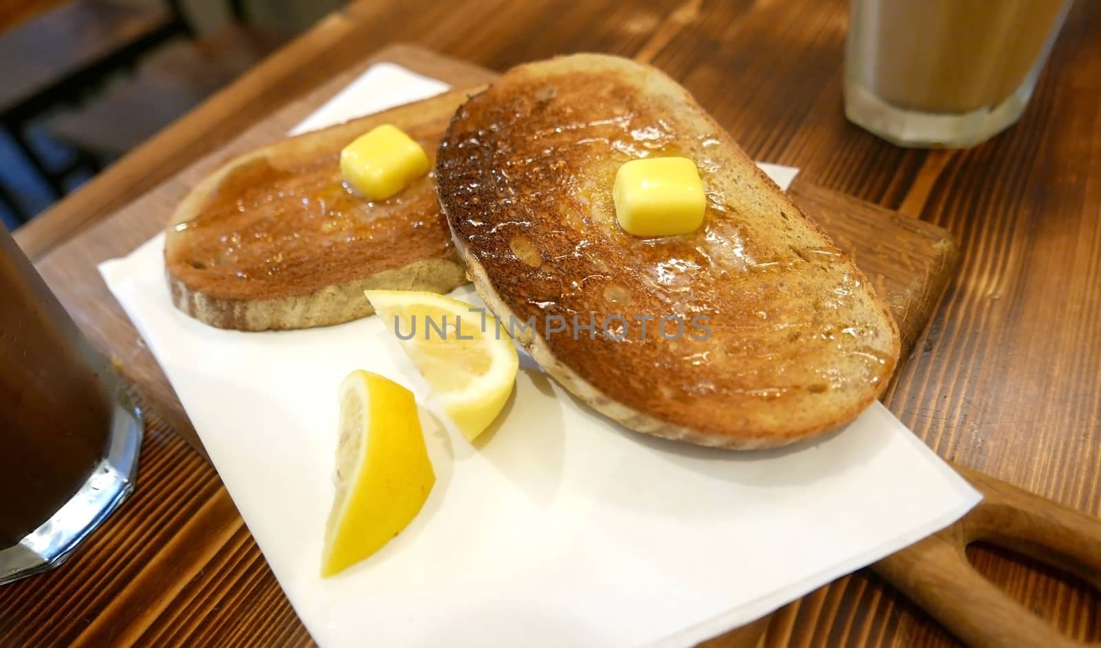 Breakfast butter lemon honey bread with cold drink on the wooden table by cougarsan