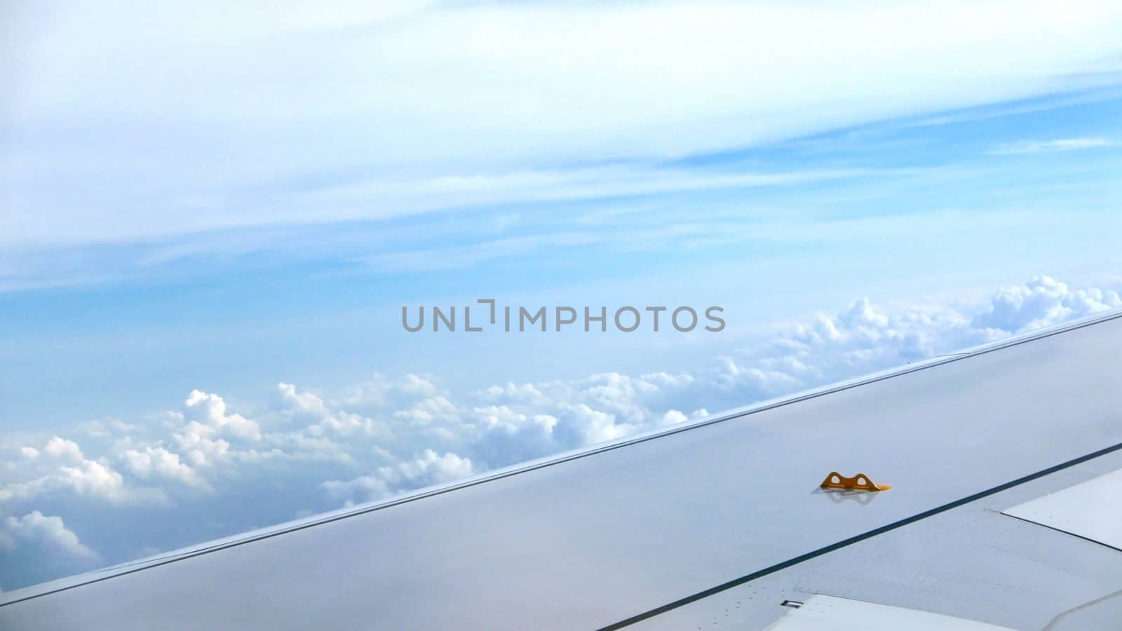 Airplane wing, white cloud and clean blue sky
