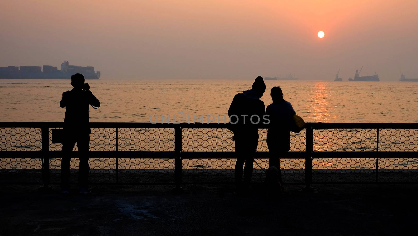 a couple of lovers are dating and a man is taking photos at sunset by cougarsan