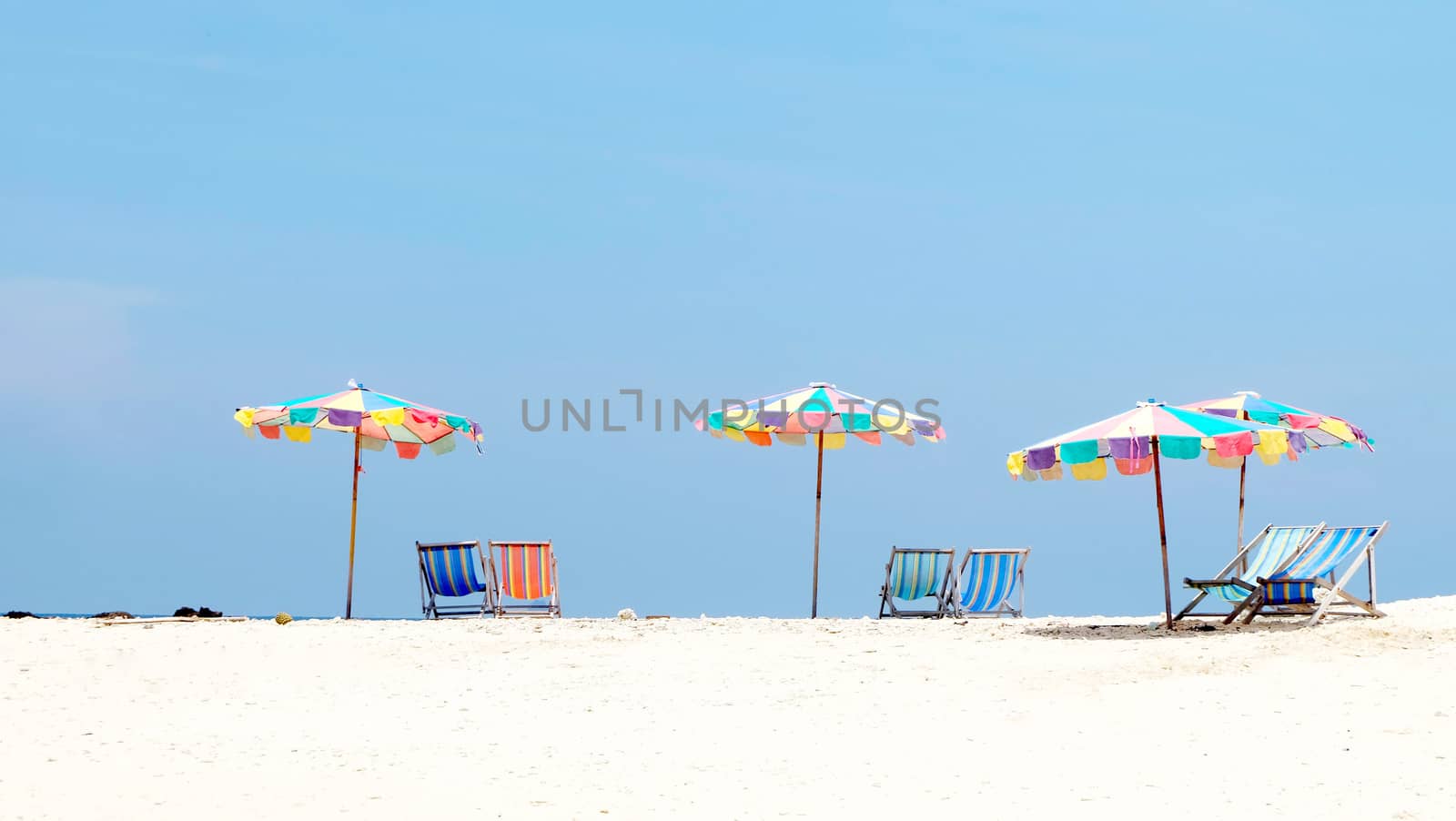 Suntanning umbrella and chair on the beach by cougarsan