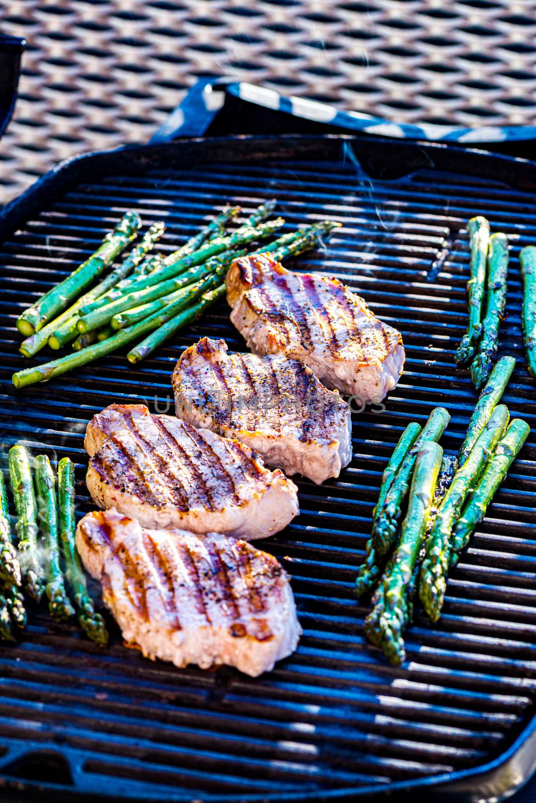 Pork chops and asparagus on grill surface