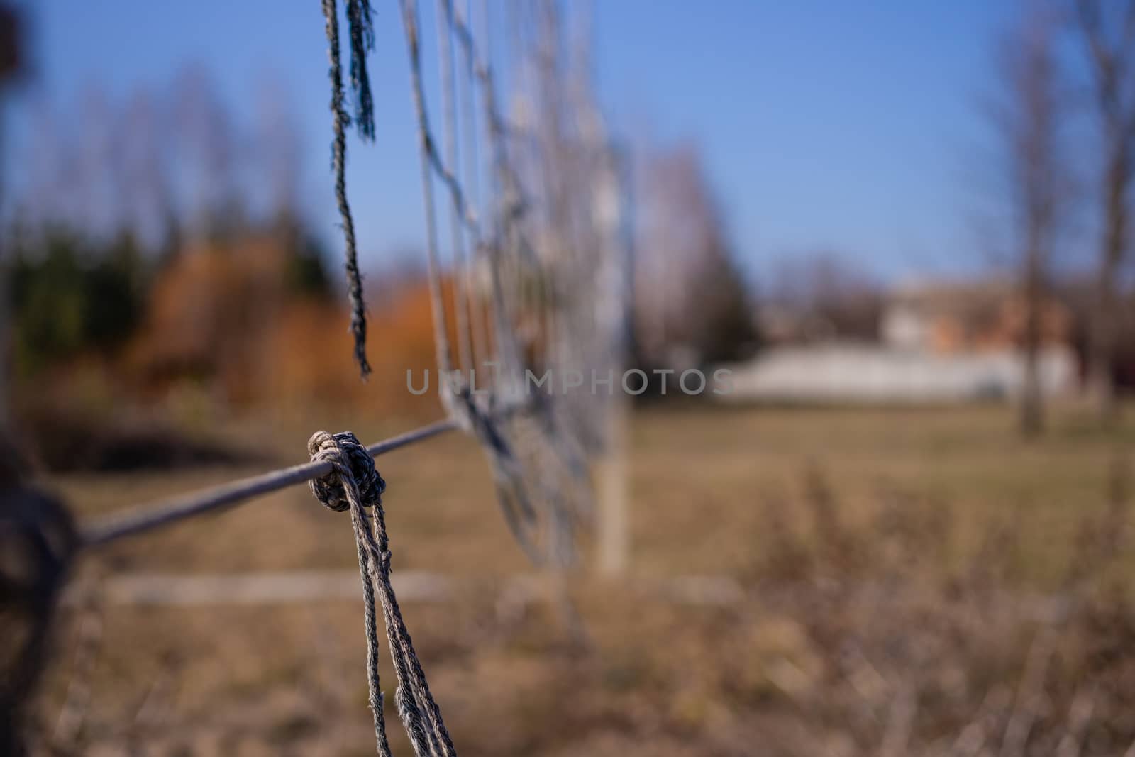 Torn volleyball net in an abandoned stadium. It`s autumn time outside. Post apocalyptic concept.