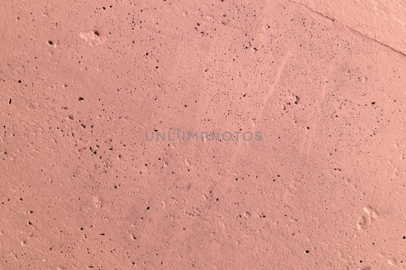 The pink concrete wall. The wall is textured.