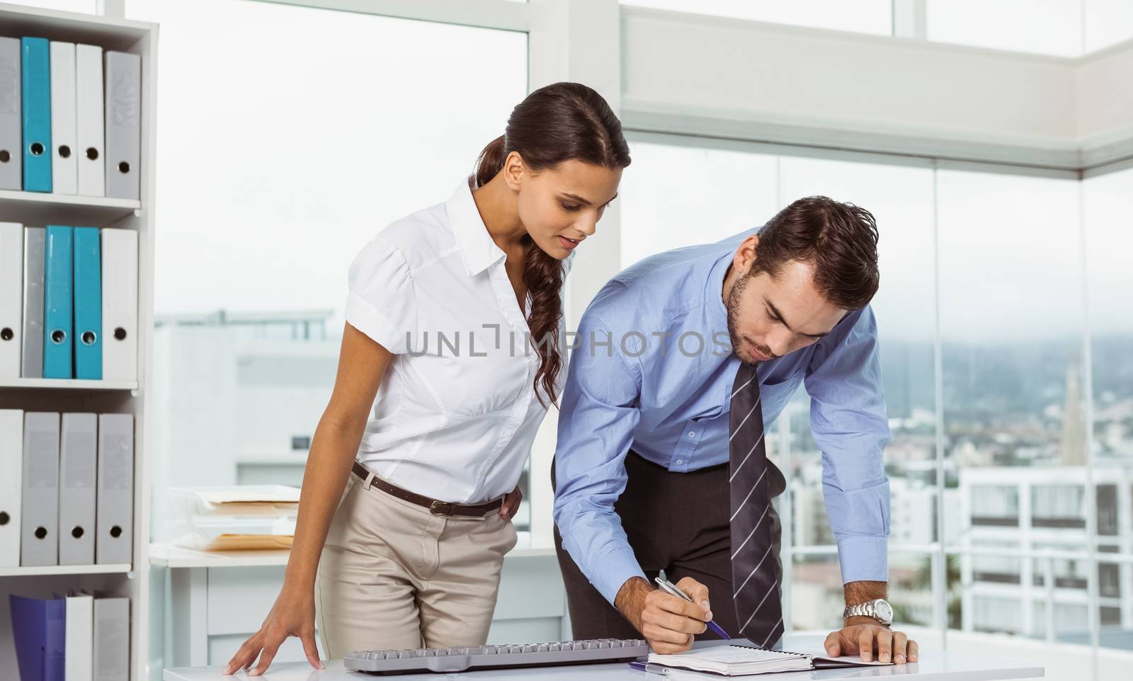 Two young business people with diary in the office