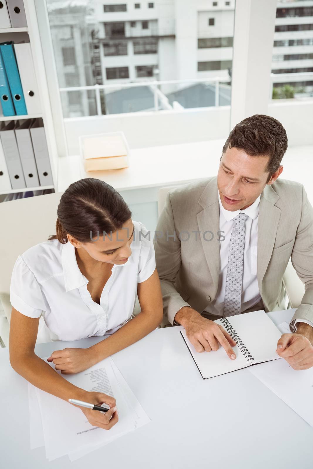 Two young business people with diary in the office