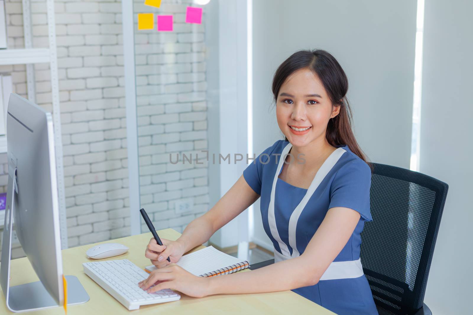 Asian businesswoman smiles brightly while doing important transa by panyajampatong