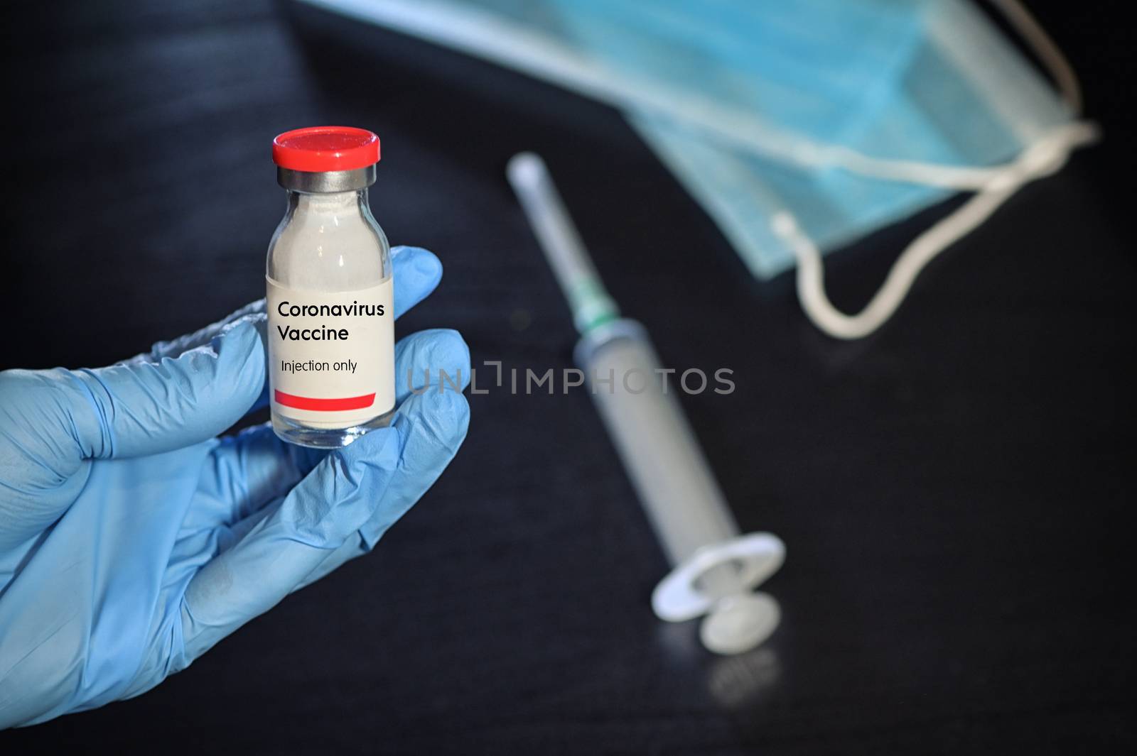 Hand With Glove Holding Coronavirus Vaccine by mady70