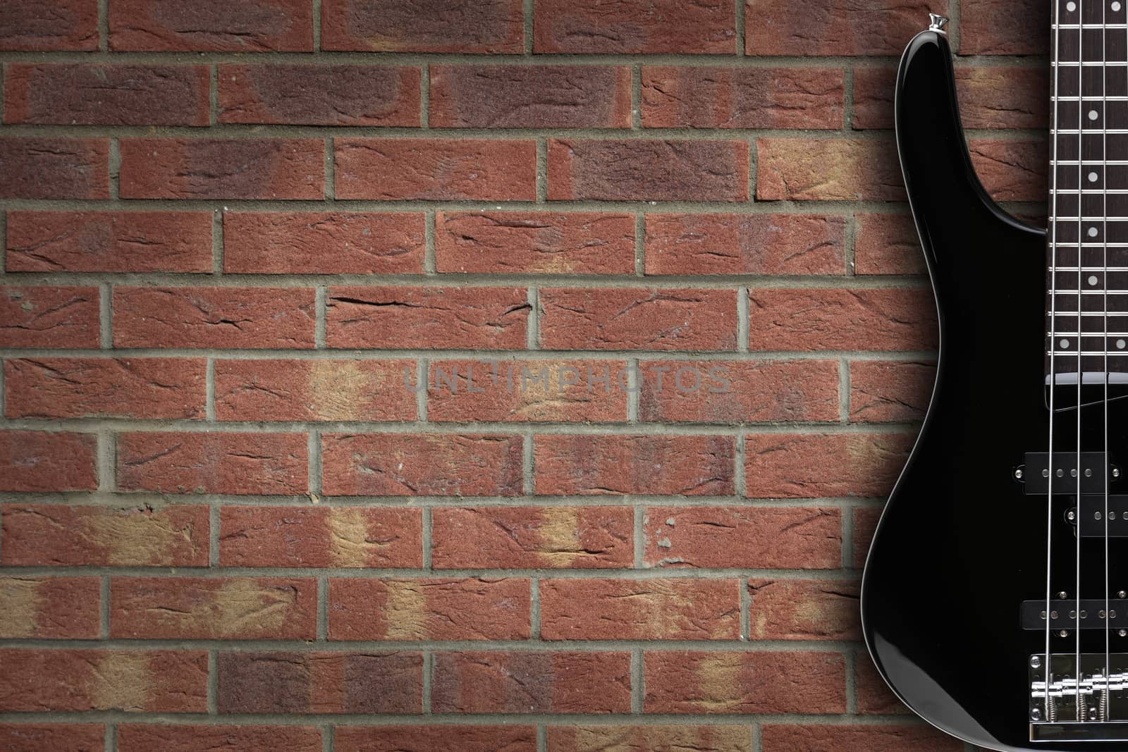 A bass guitar on brick background with copy space