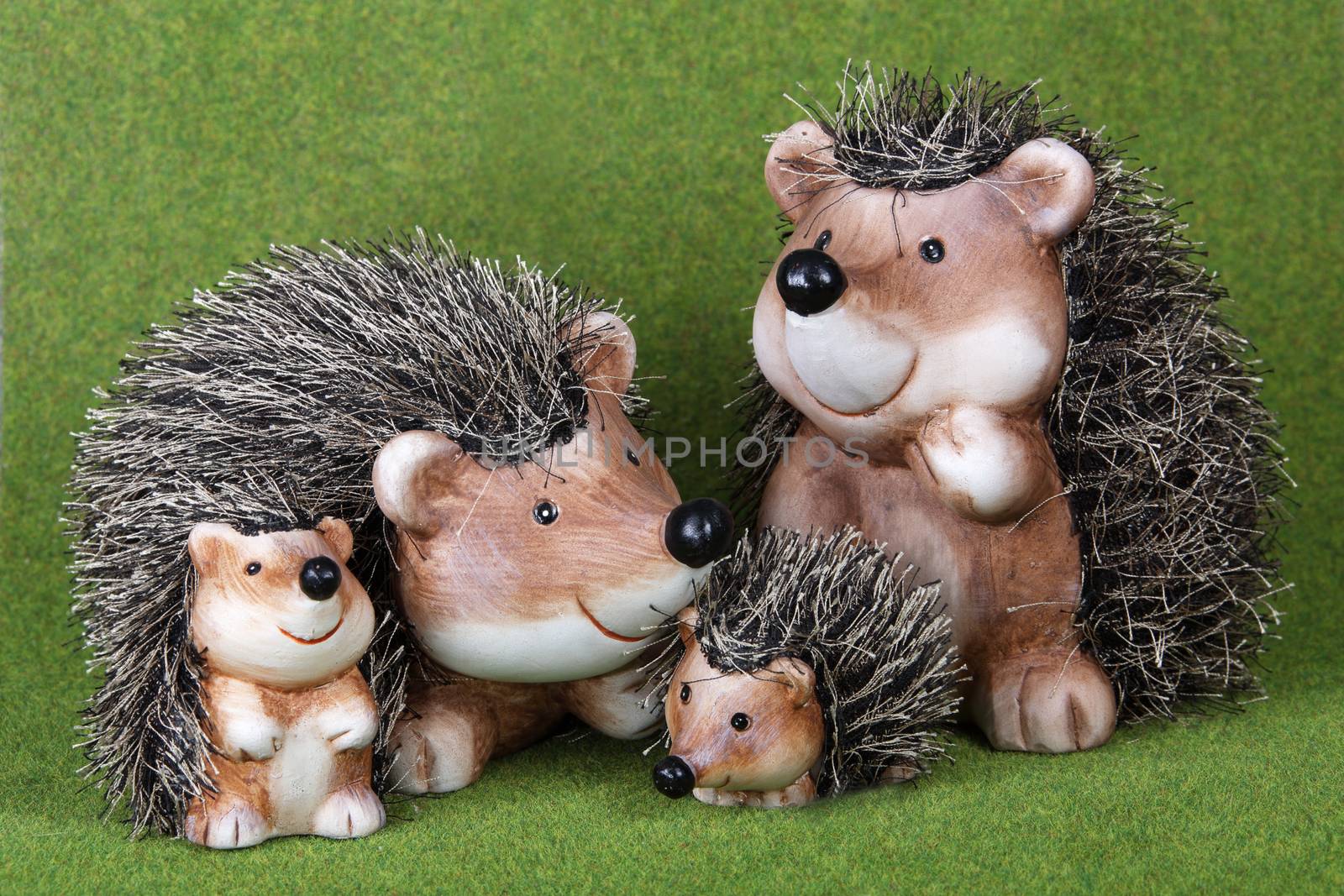 A family of cute toy Hedgehogs together on grass