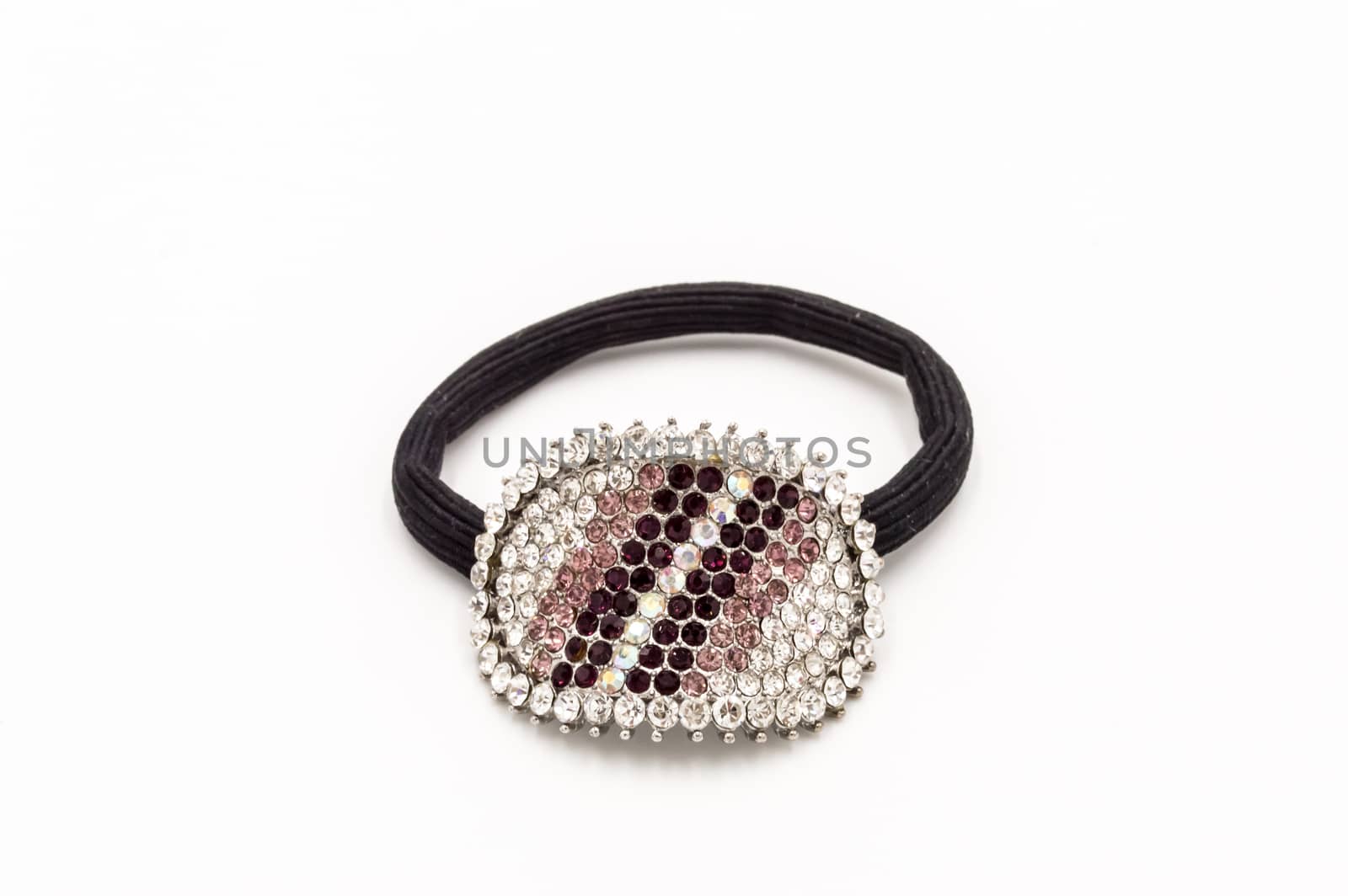 Hair elastic with a brooch set with stones on a white background