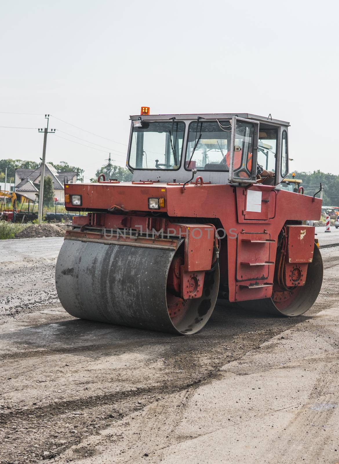 Orange Heavy Vibration roller compactor at asphalt pavement works for road repairing. Working on the new road construction site. Repairing