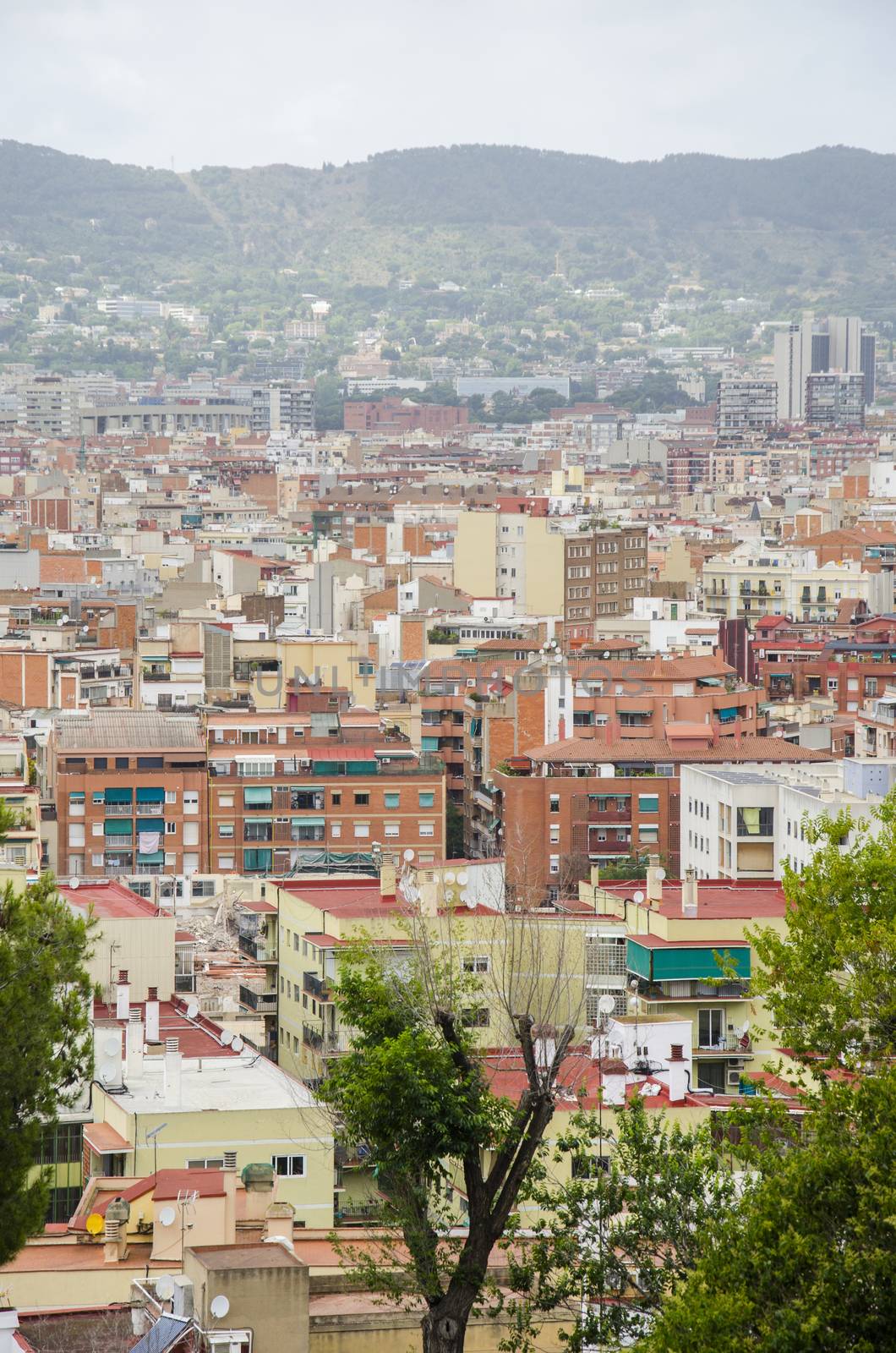 Roofs of Barcelona. Piece of the city of Barcelona seen from above shows architecture of a general air view in a summer day. Cityscape of rooftops in the L'Eixample district. Catalonia,Spain