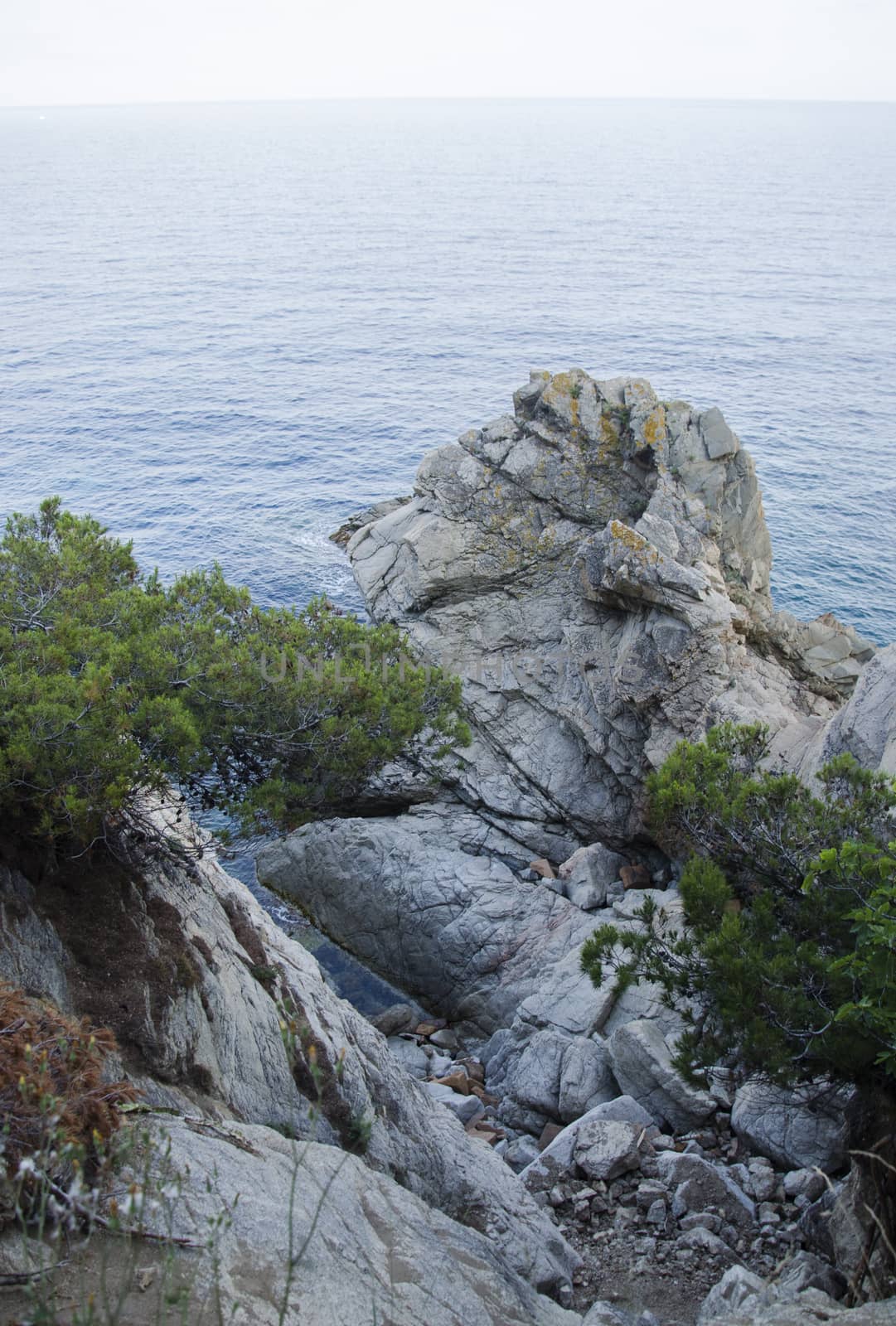 Rocks on the coast of Lloret de Mar in a beautiful summer day, Costa Brava, Catalonia, Spain. Waterfront of Lloret de Mar Costa Brava Spain. Rocks on the coast of Lloret de Mar