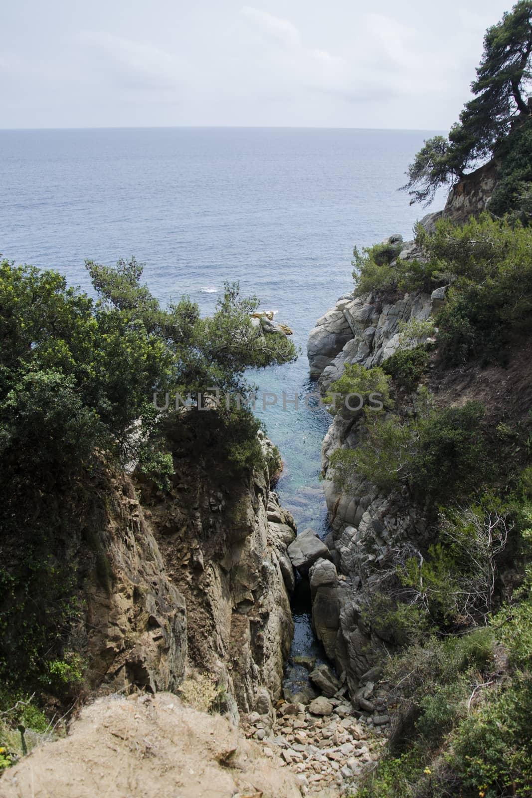 Rocks on the coast of Lloret de Mar in a beautiful summer day, Costa Brava, Catalonia, Spain. Waterfront of Lloret de Mar Costa Brava Spain. Rocks on the coast of Lloret de Mar