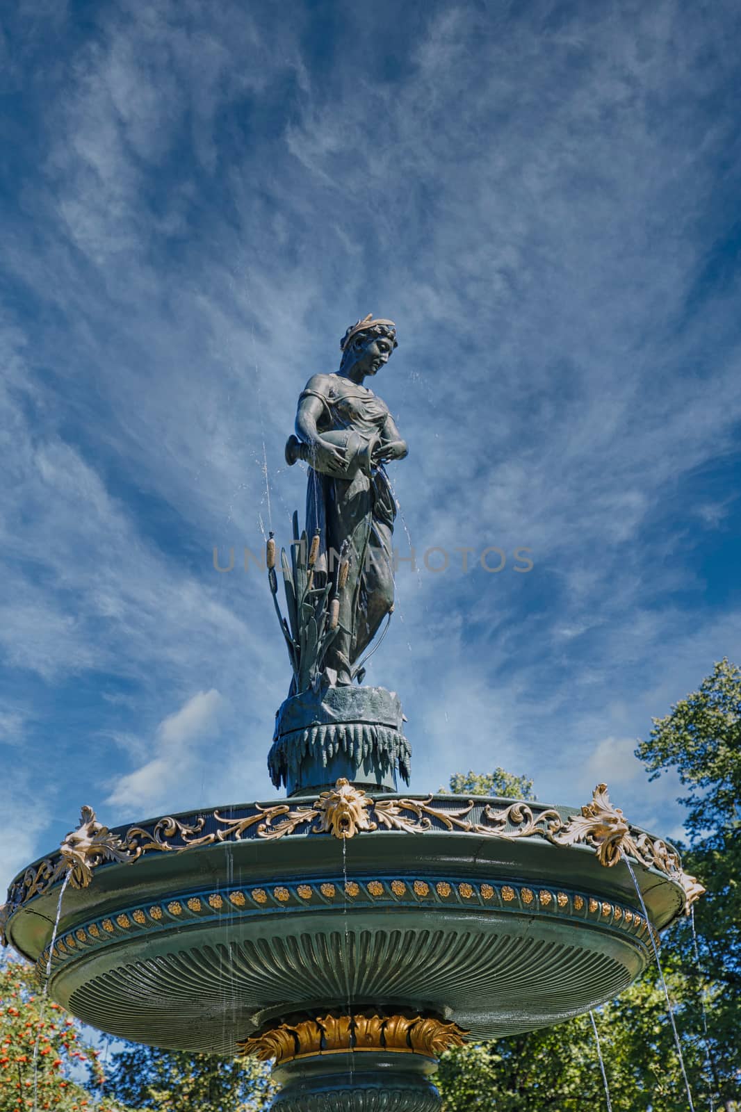 An old statue on a fountain in a public garden
