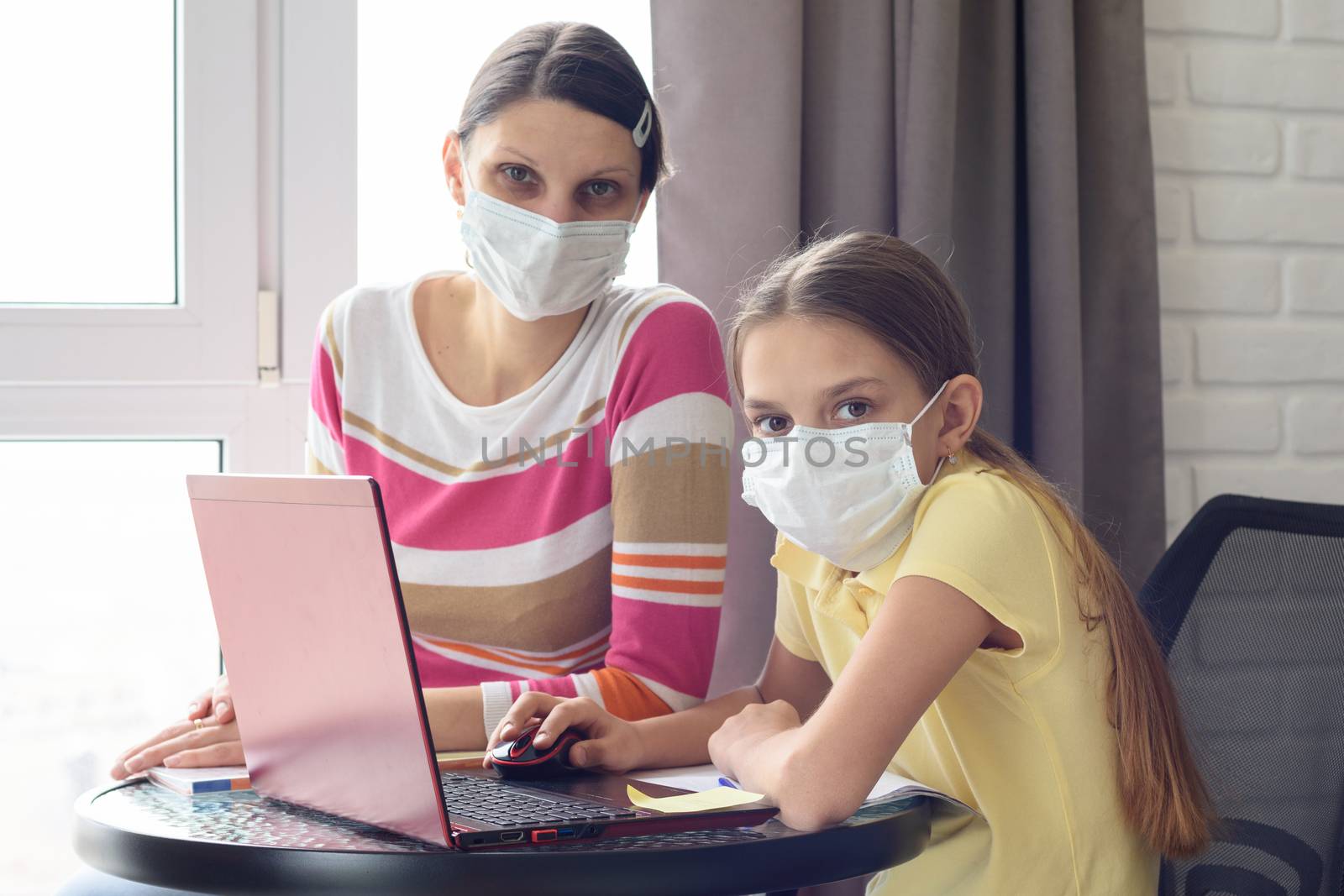 The quarantined family in the isolation ward, mom and daughter doing homework, looked into the frame