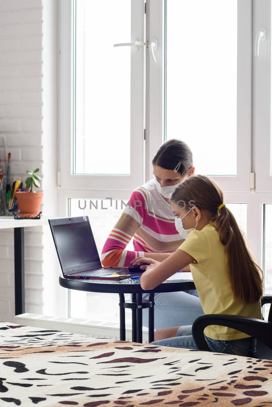 Self-isolation, mom and daughter study at school online via the Internet