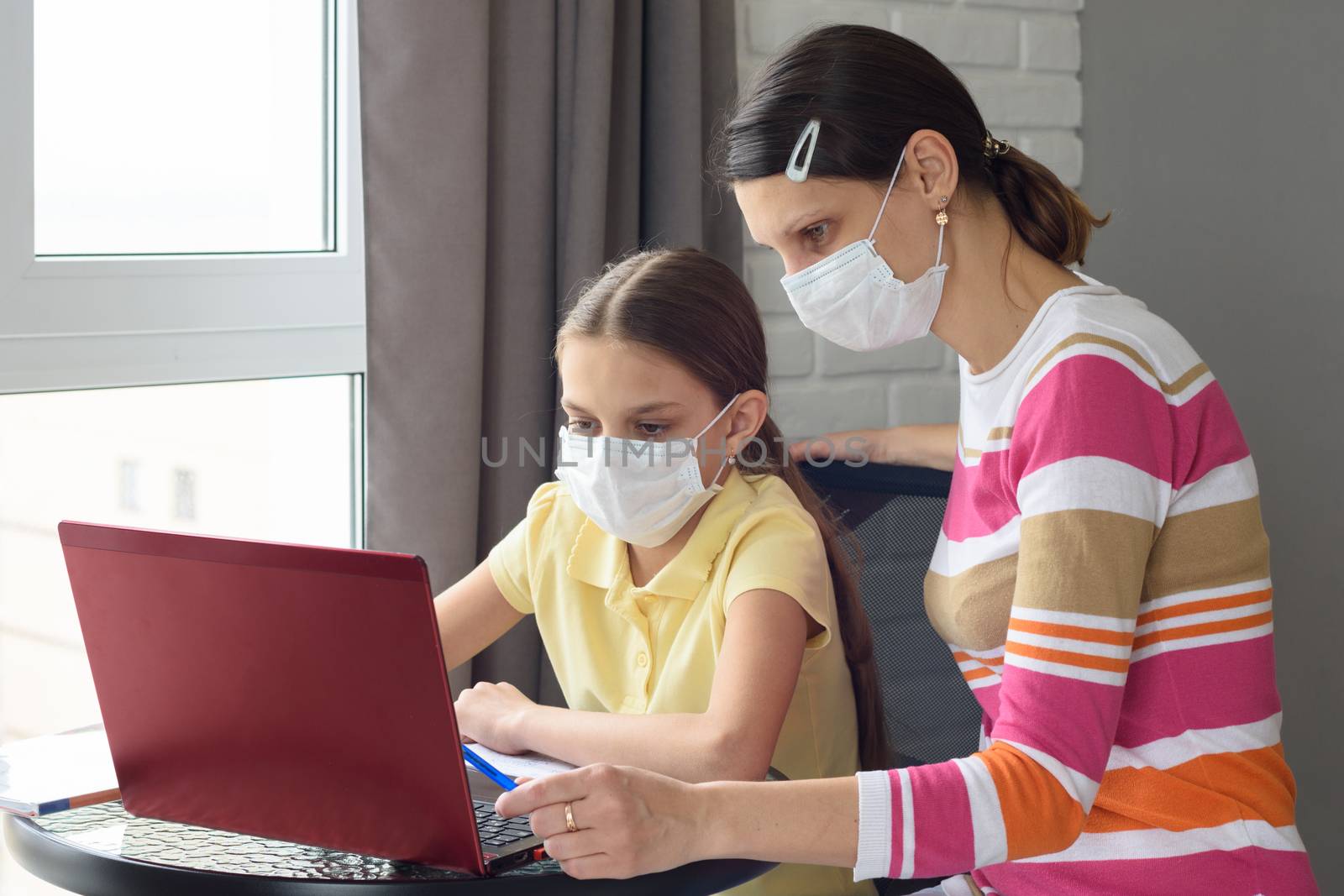 quarantined girl and girl perform school tasks online