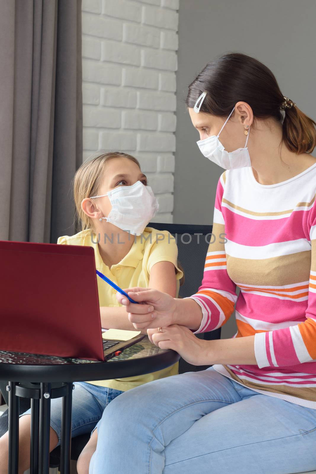 Quarantined family, daughter doing homework, mom helps her