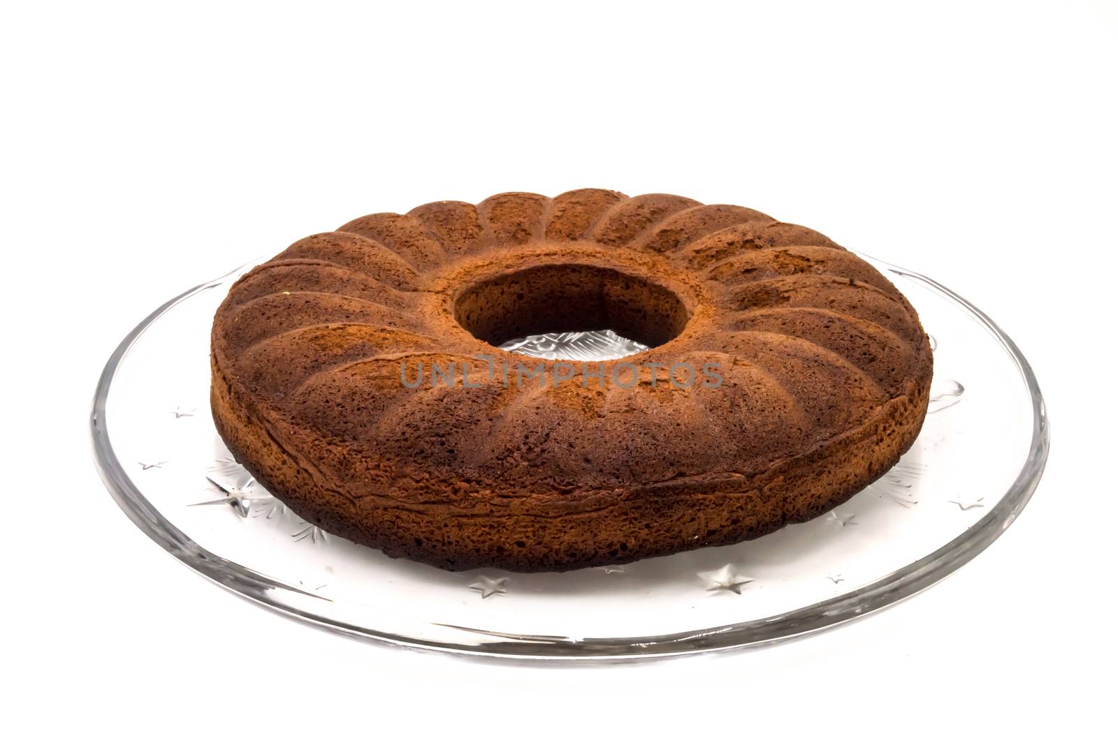 Circular marbled cake laying on a glass tray on a white background
