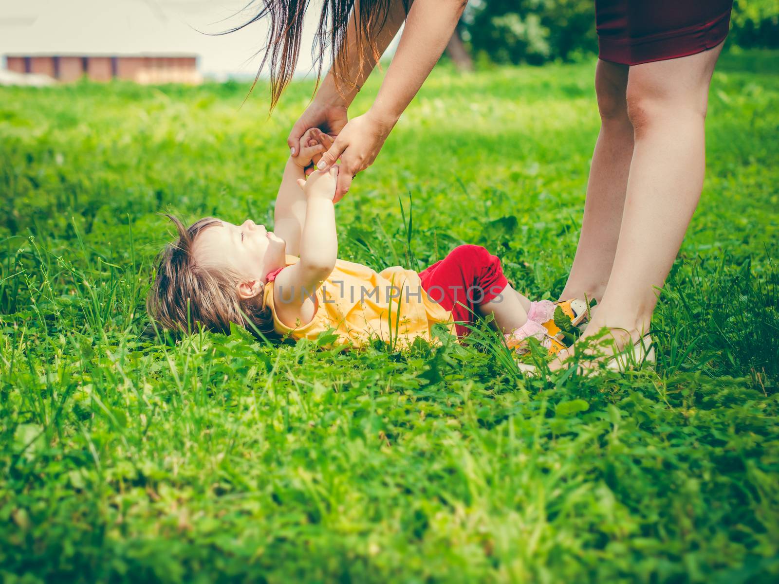 Mother and little daughter playing together outdoors