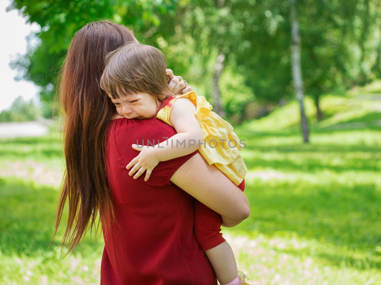 Mother holding crying baby girl with tears by fascinadora