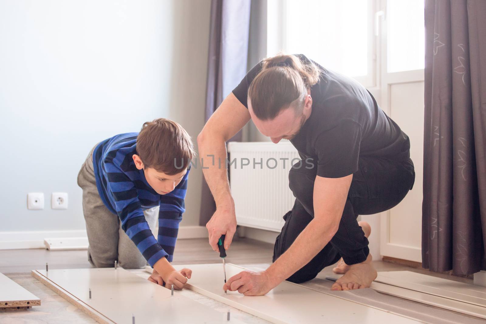 Father and son working together by destillat