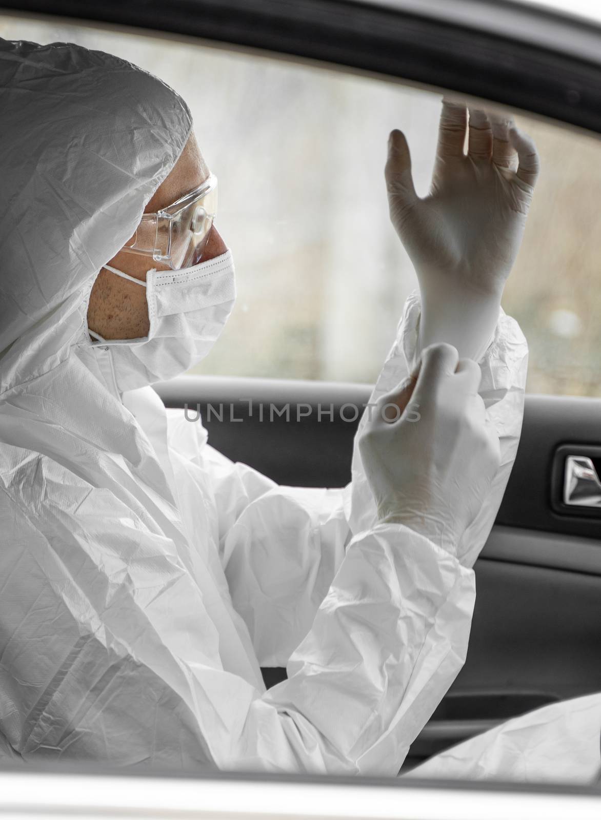 Man in protective suit, medical mask and rubber gloves for protect from bacteria and virus is planning to drive. Protective mask while quarantine, world pandemic, covid 19, coronavirus, infection