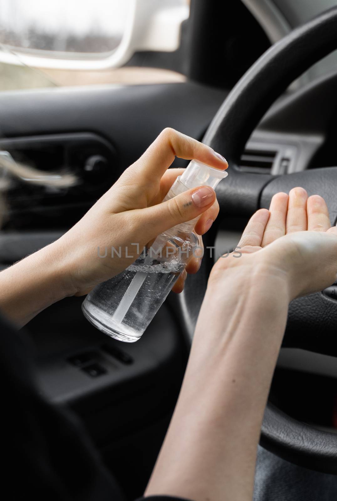 Woman is using antiseptic for protect himself from bacteria virus while planning to drive. Antiseptic while quarantine, pandemic, covid 19, coronavirus, infection