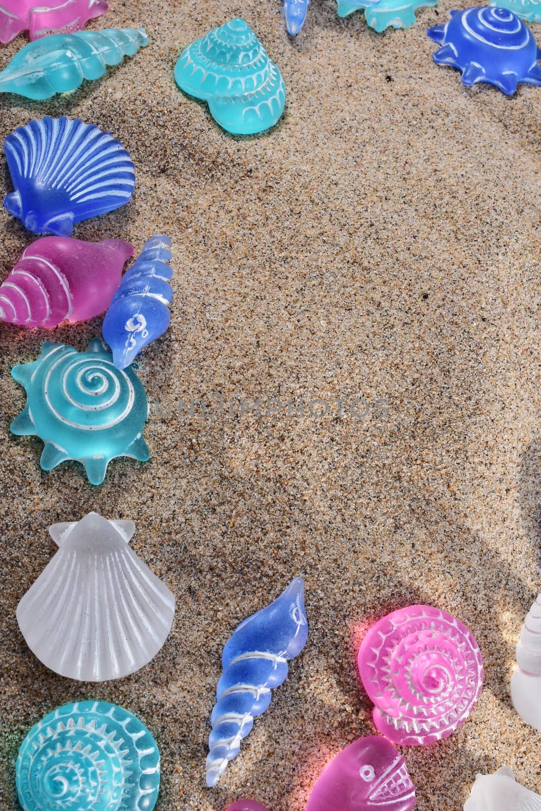 summer background and concept of beach with sand and artificial seashells