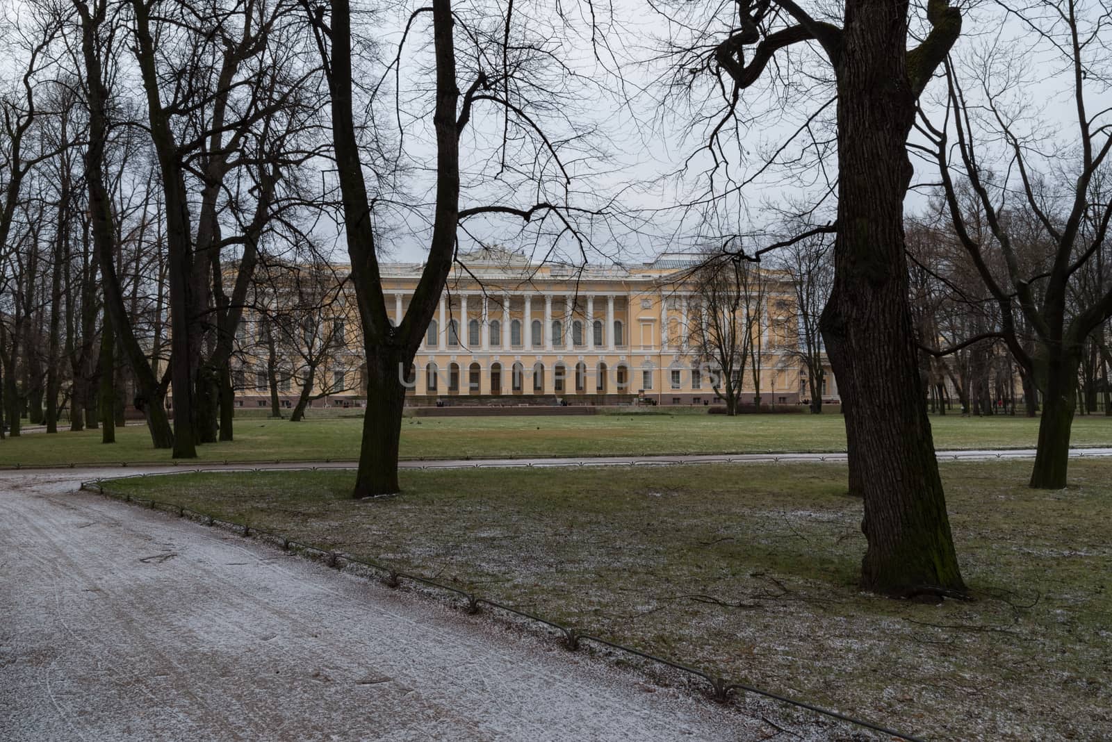 Saint Petersburg, Russia - January 1, 2020: Alley in Mikhailovsky garden at winter with Russian Museum at background.