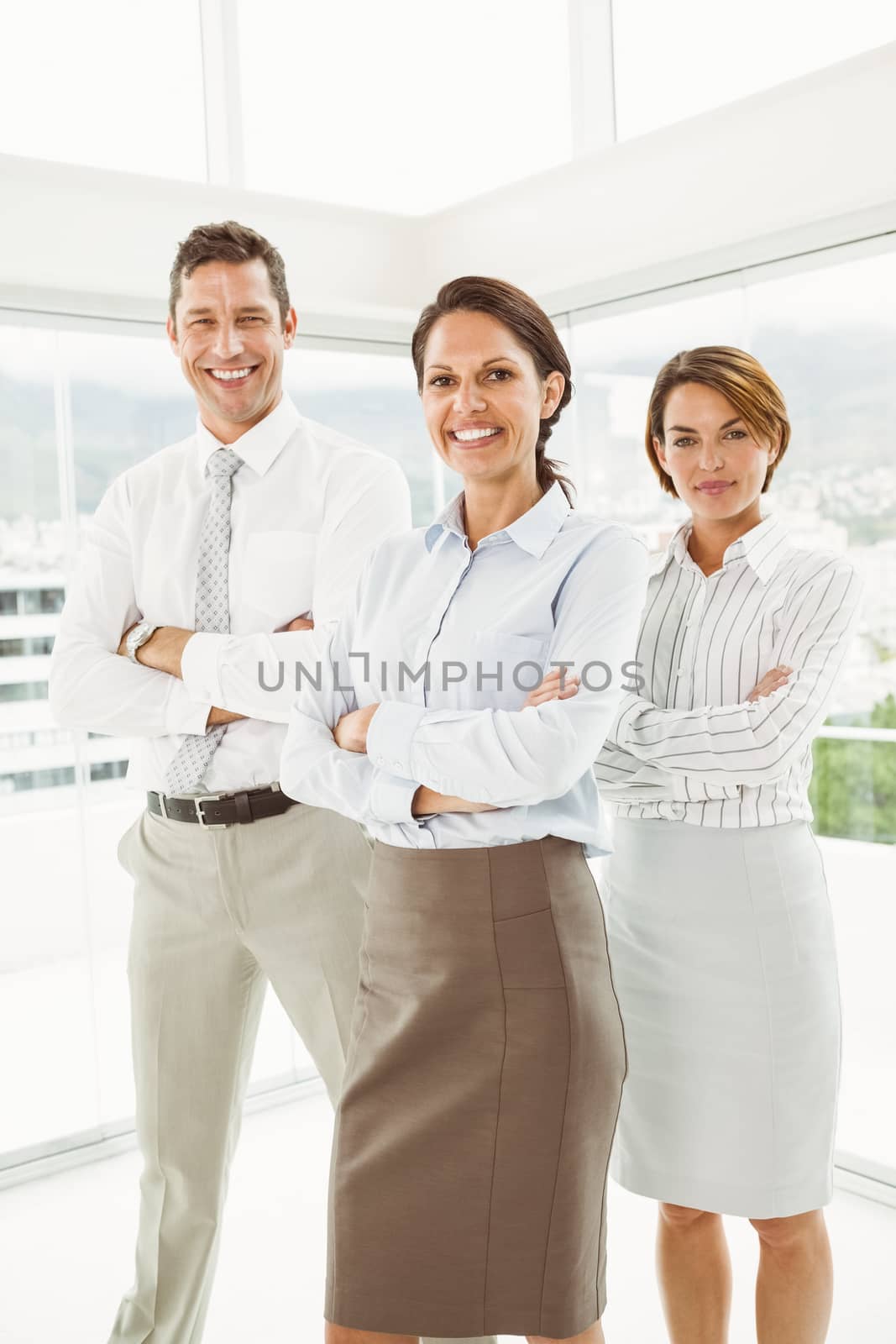 Portrait of confident young business people with arms crossed in office