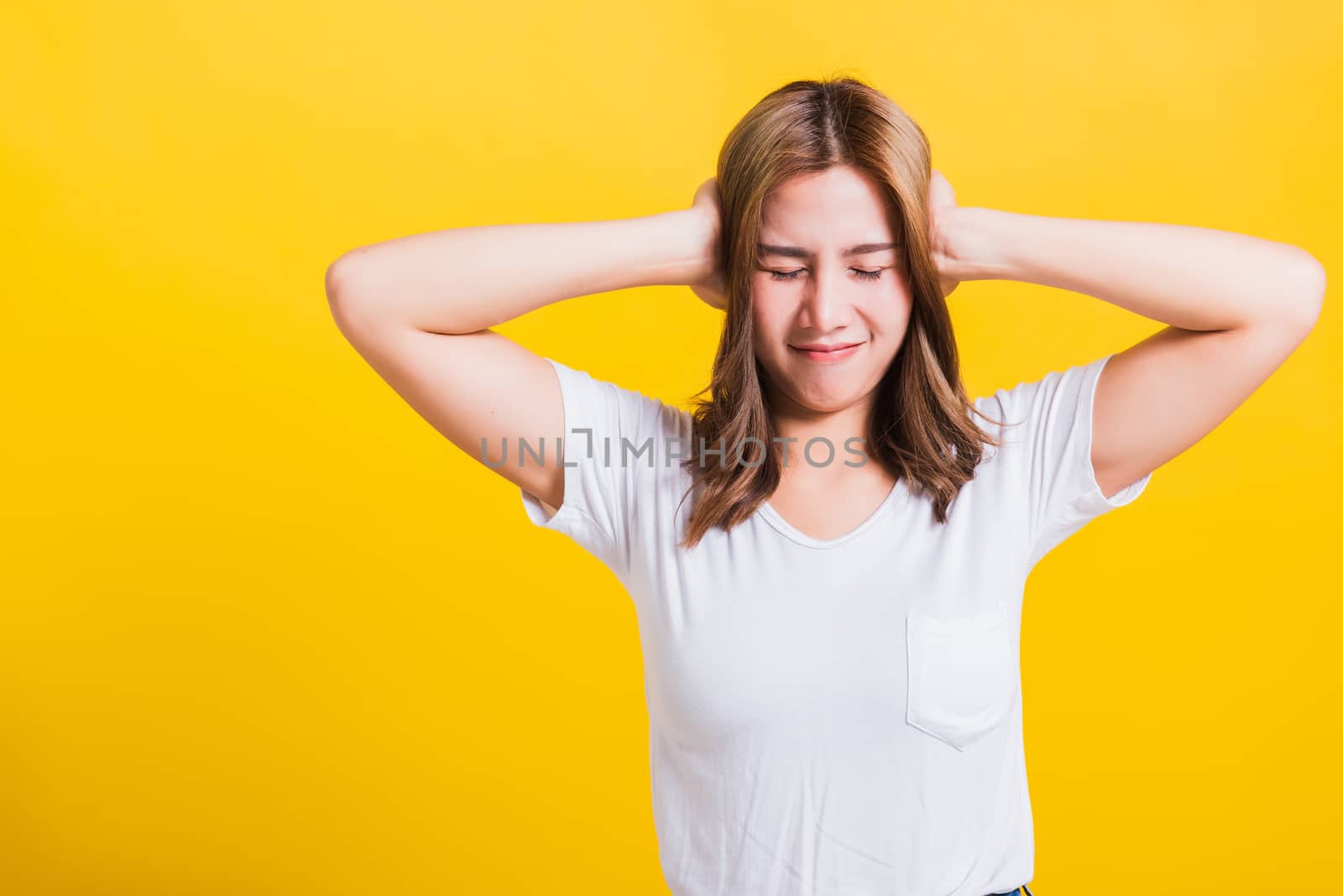 Asian Thai happy portrait beautiful cute young woman smile have closed palms ears with palms and close eyes, studio shot isolated on yellow background with copy space
