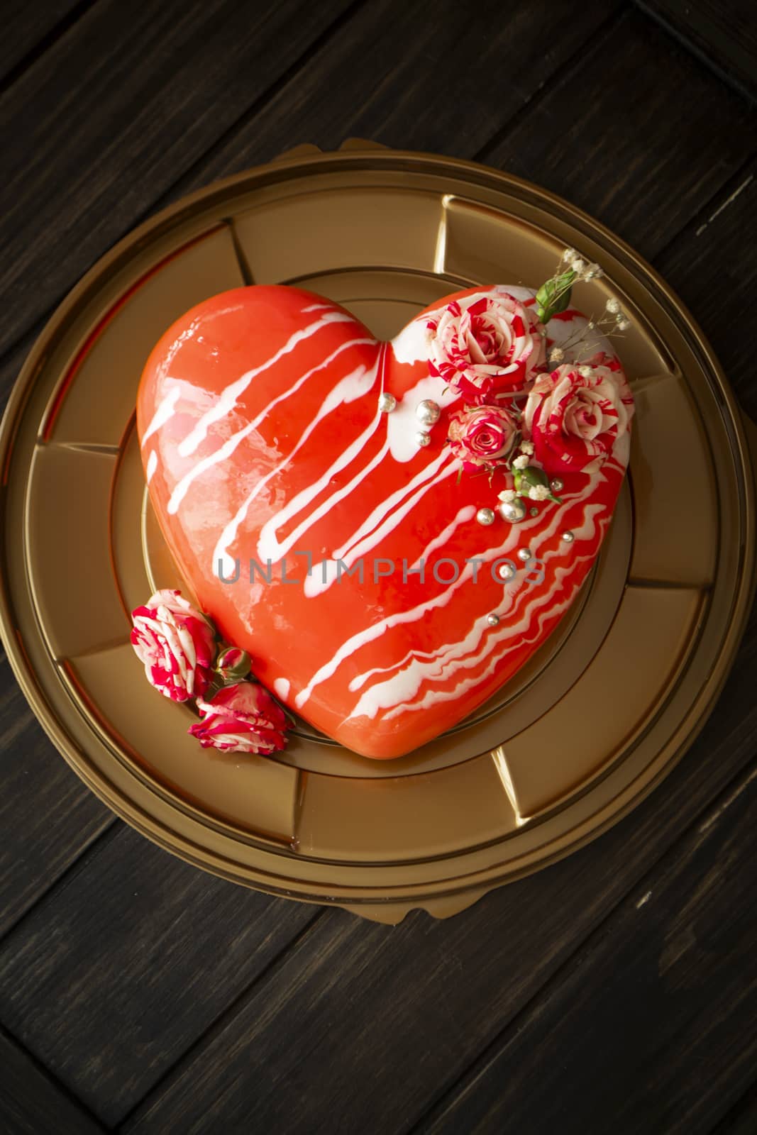 Chocolate and strawberry mousse cake in the shape of red heart with roses.