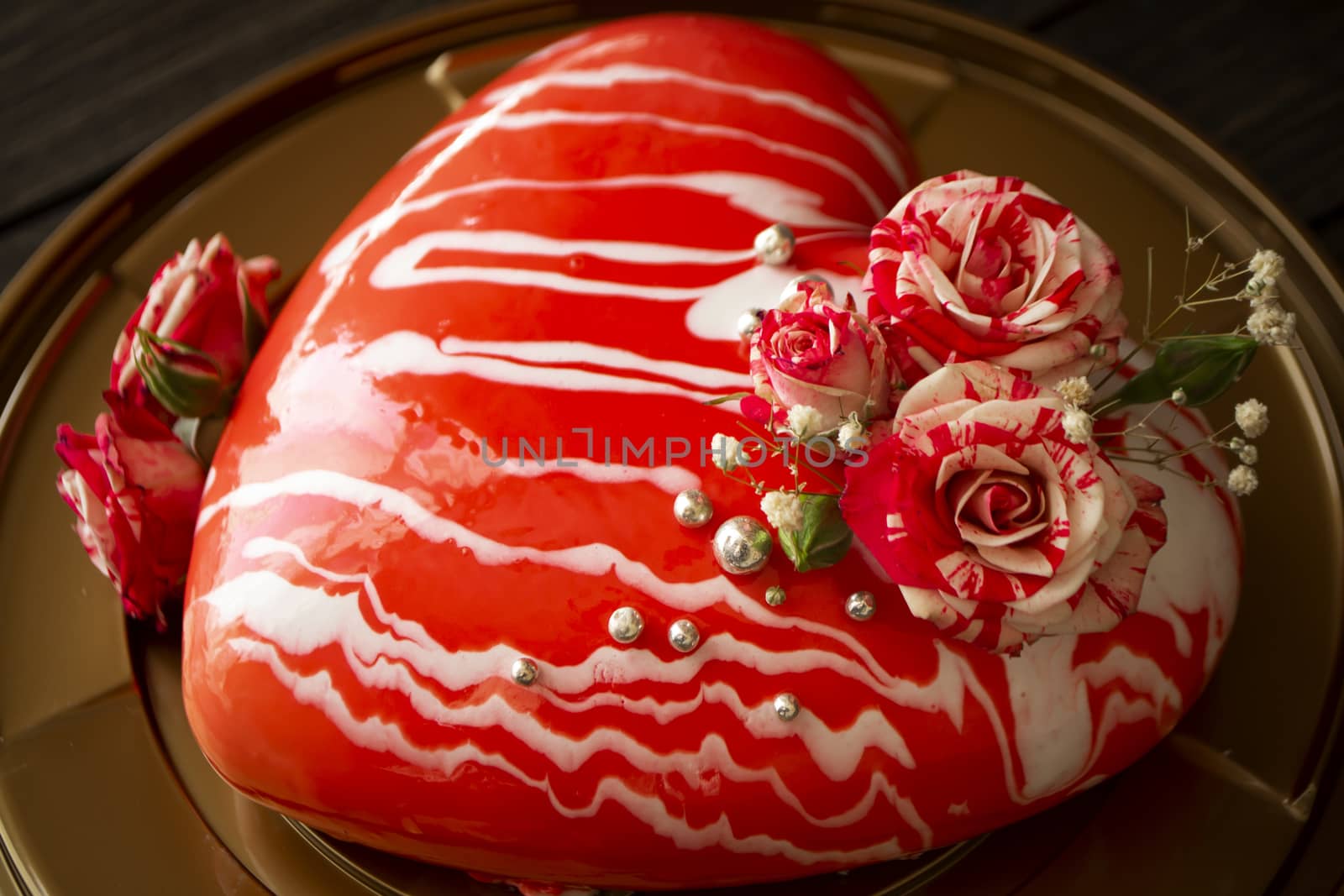 Modern mousse cake in the shape of heart. With roses, closeup