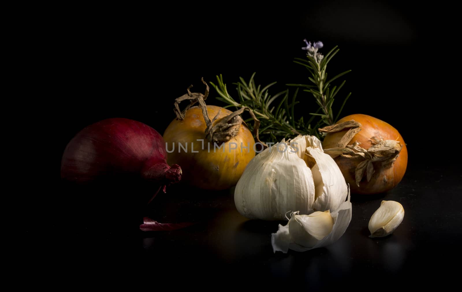 still life of Garlic and onion vegetables with rosemary spice ion black background