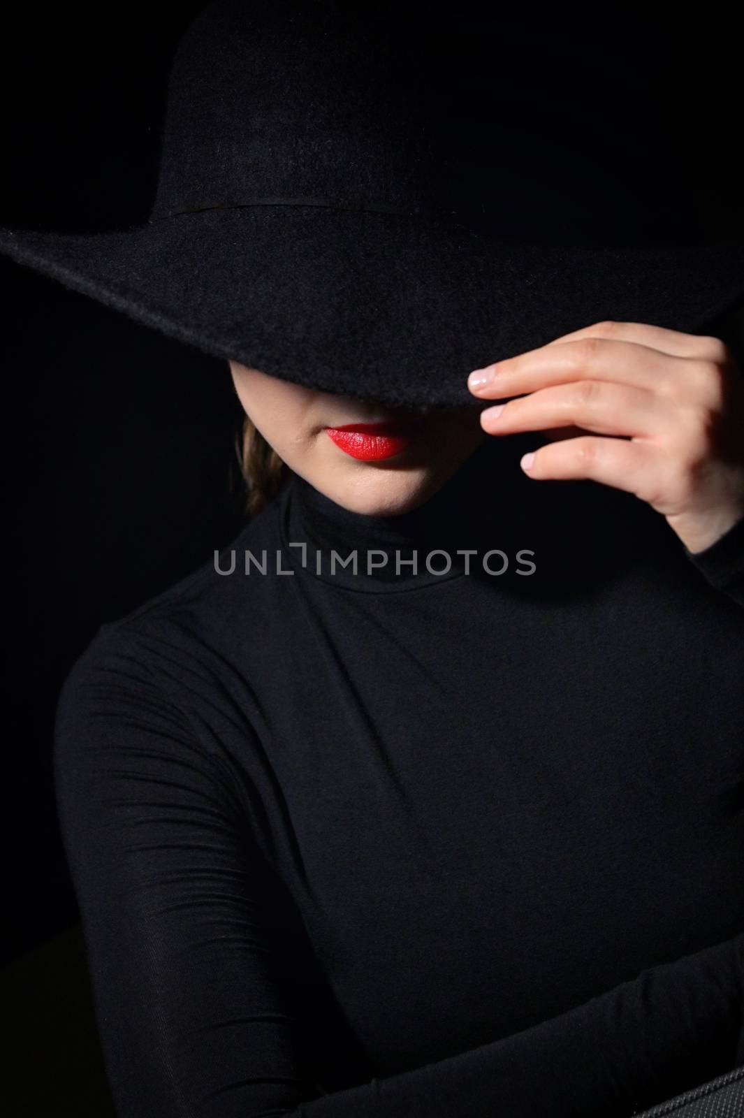 A Woman With Red Lips In A Black Hat On A Black Background