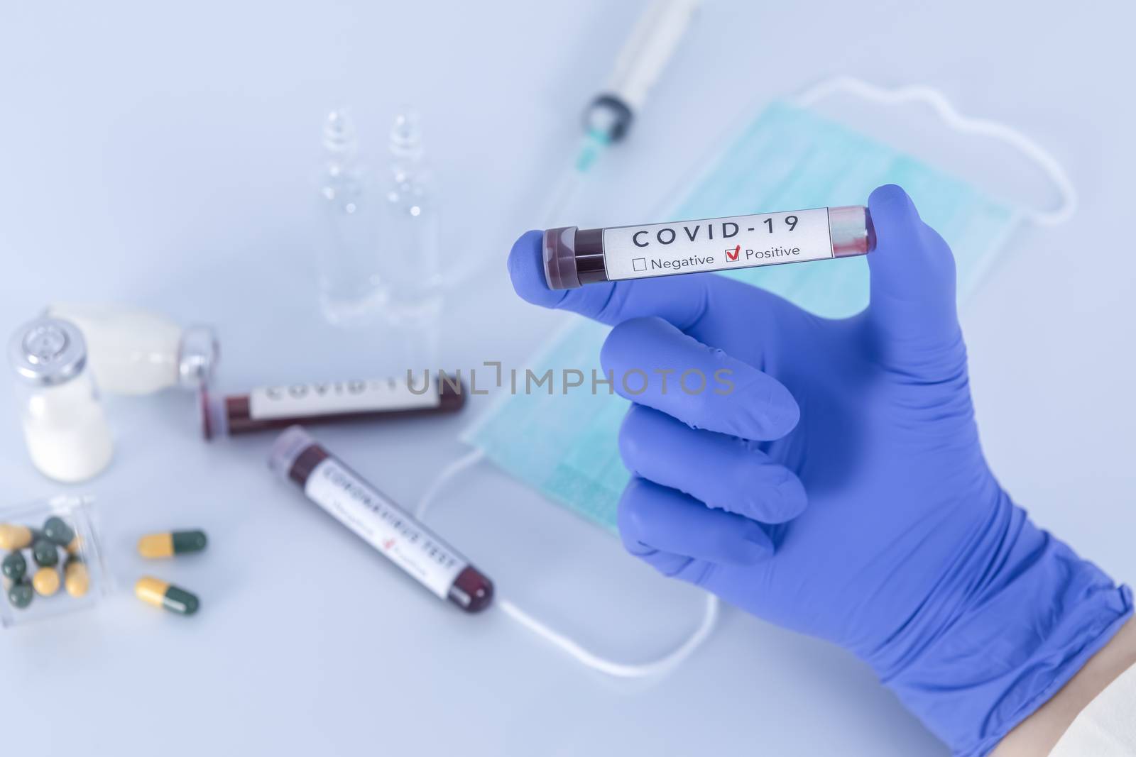 Analyst hand with protective gloves holding COVID 19 Coronavirus test blood. Virus test and research concept. Focus on test blood.