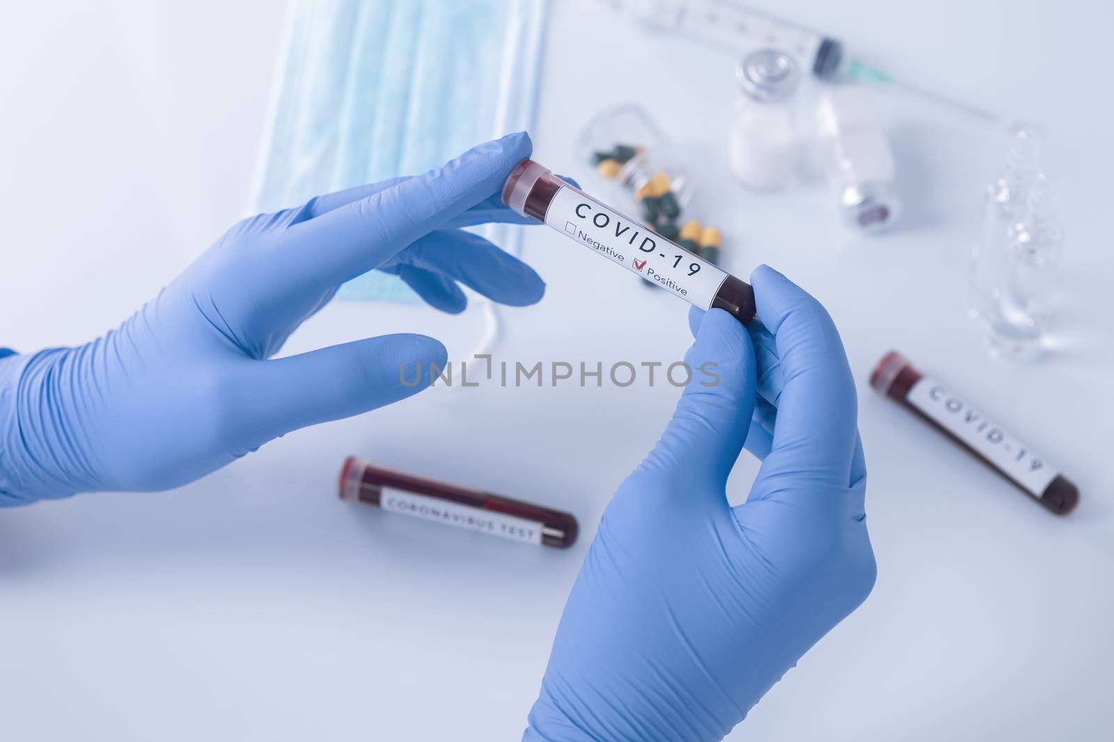 Analyst hands with protective gloves holding COVID 19 Coronavirus test blood. Virus test and research concept