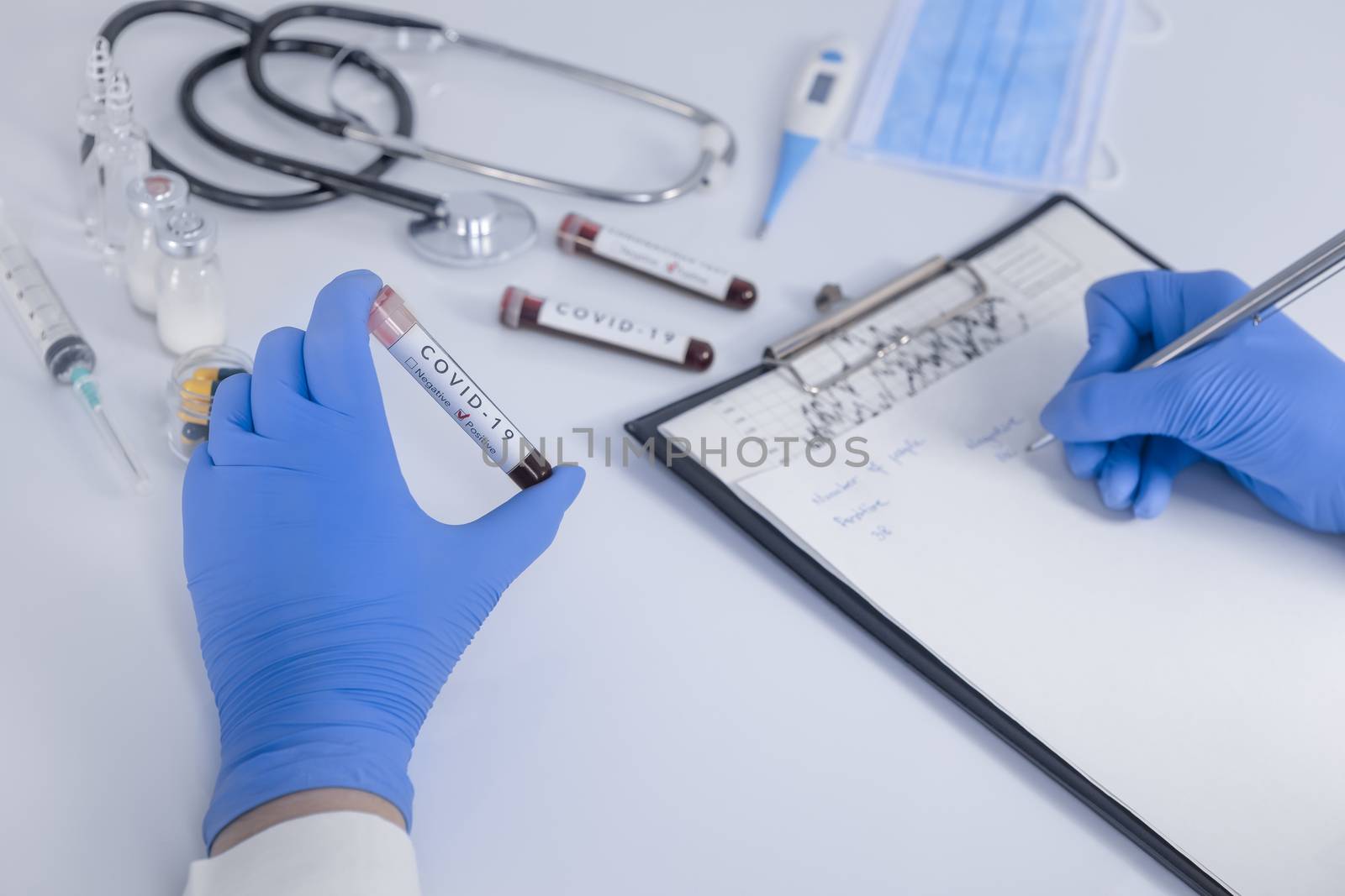 Analyst hands with protective gloves holding COVID 19 Coronavirus test blood making statistical notes. Virus test and research concept. Closeup
