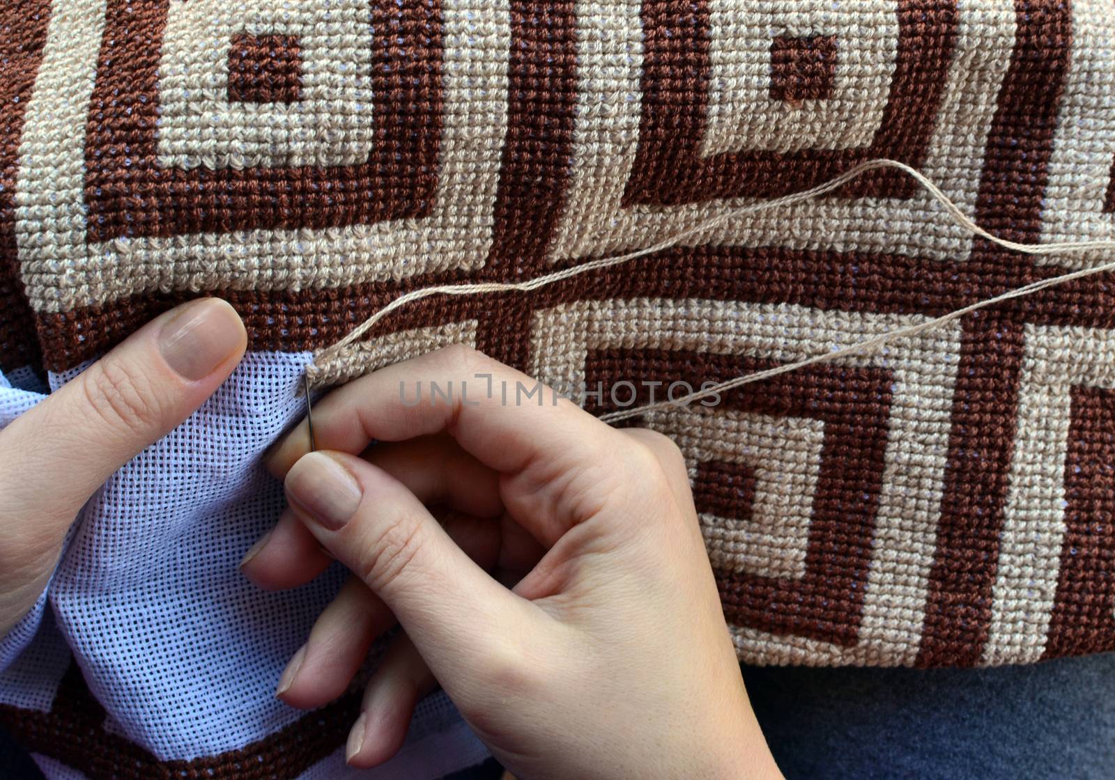 Woman embroidering traditional pattern with geometric design