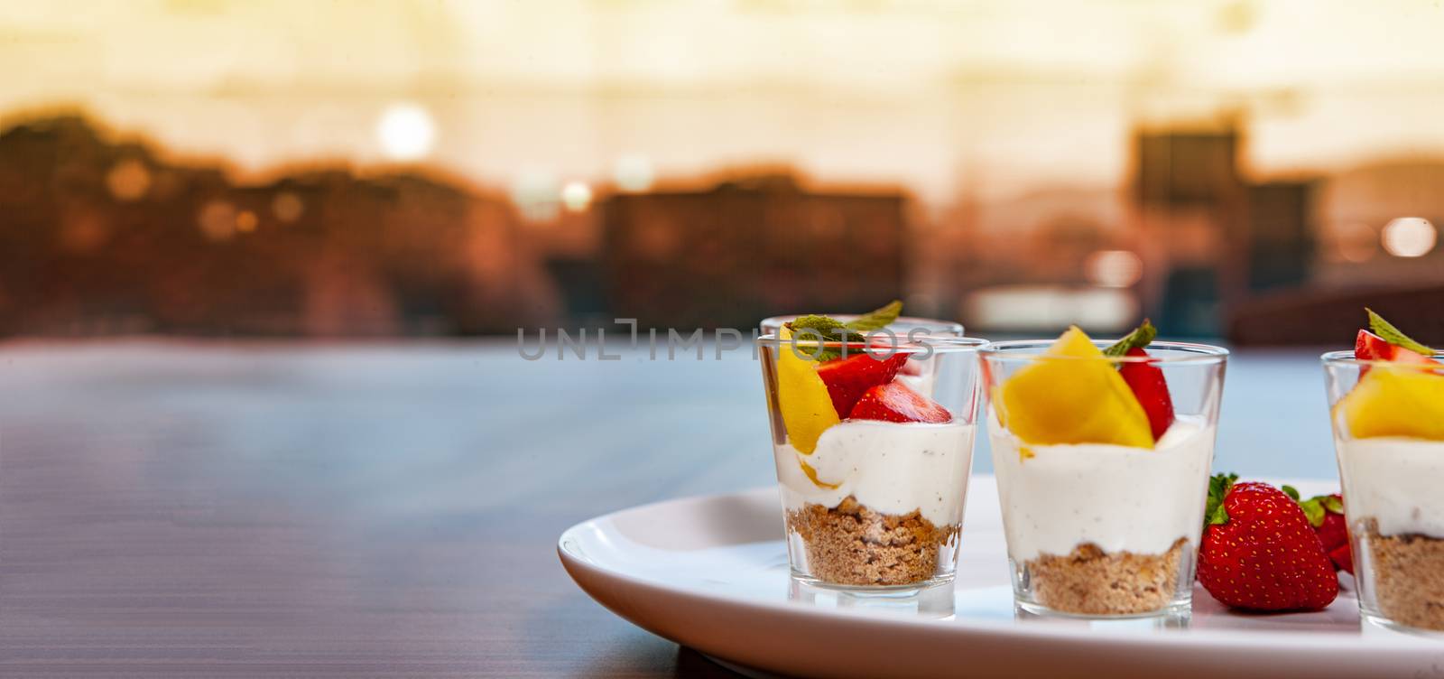 white plate with strawberries and mango. Lifestyle food served in glasses