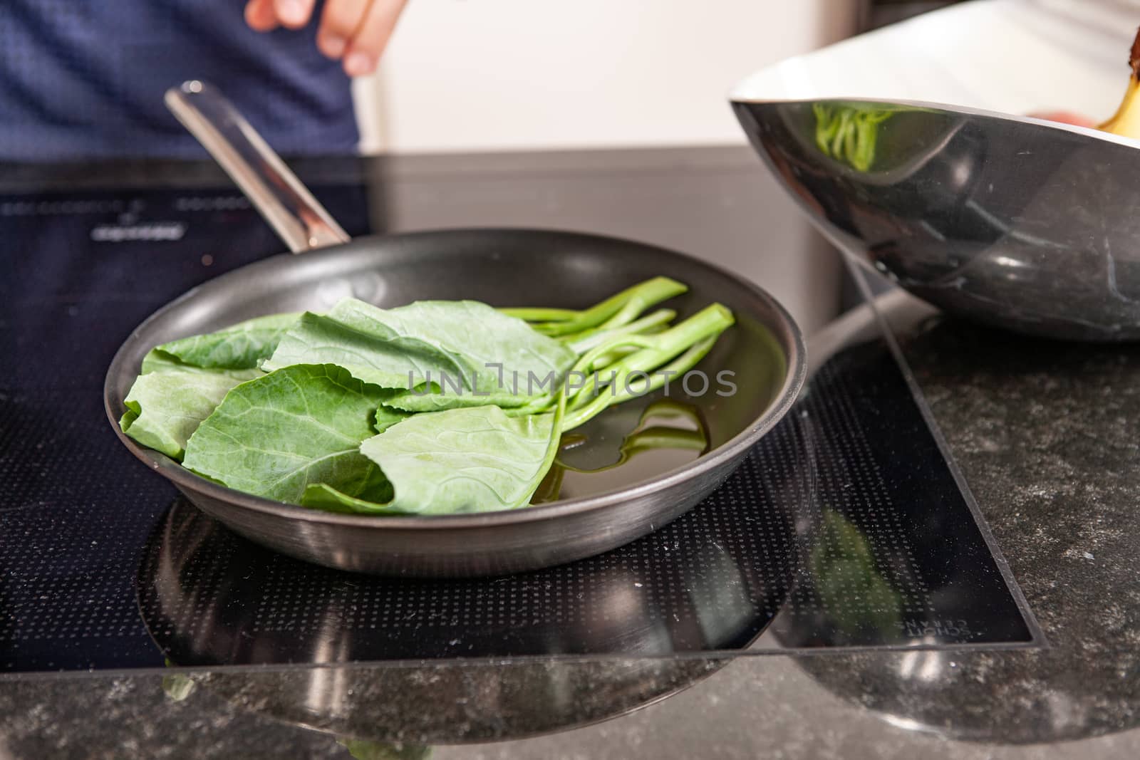 hands of cook preparing food in a frying pan by PeterHofstetter