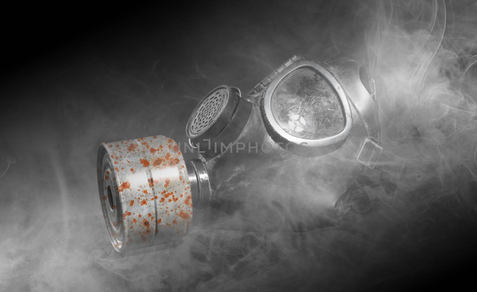 Vintage gasmask isolated on black background - Smoke in the room - Rusted filter