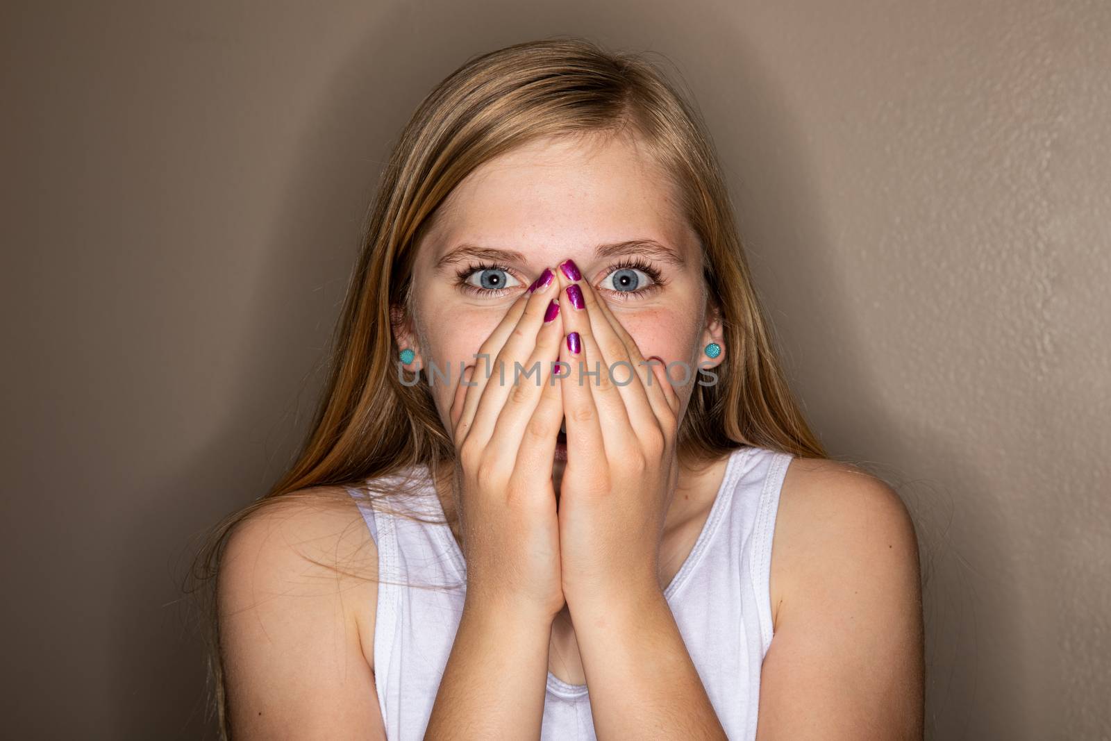 Unwell girl coughing into her hands due to either a flu, covid, or maybe allergies